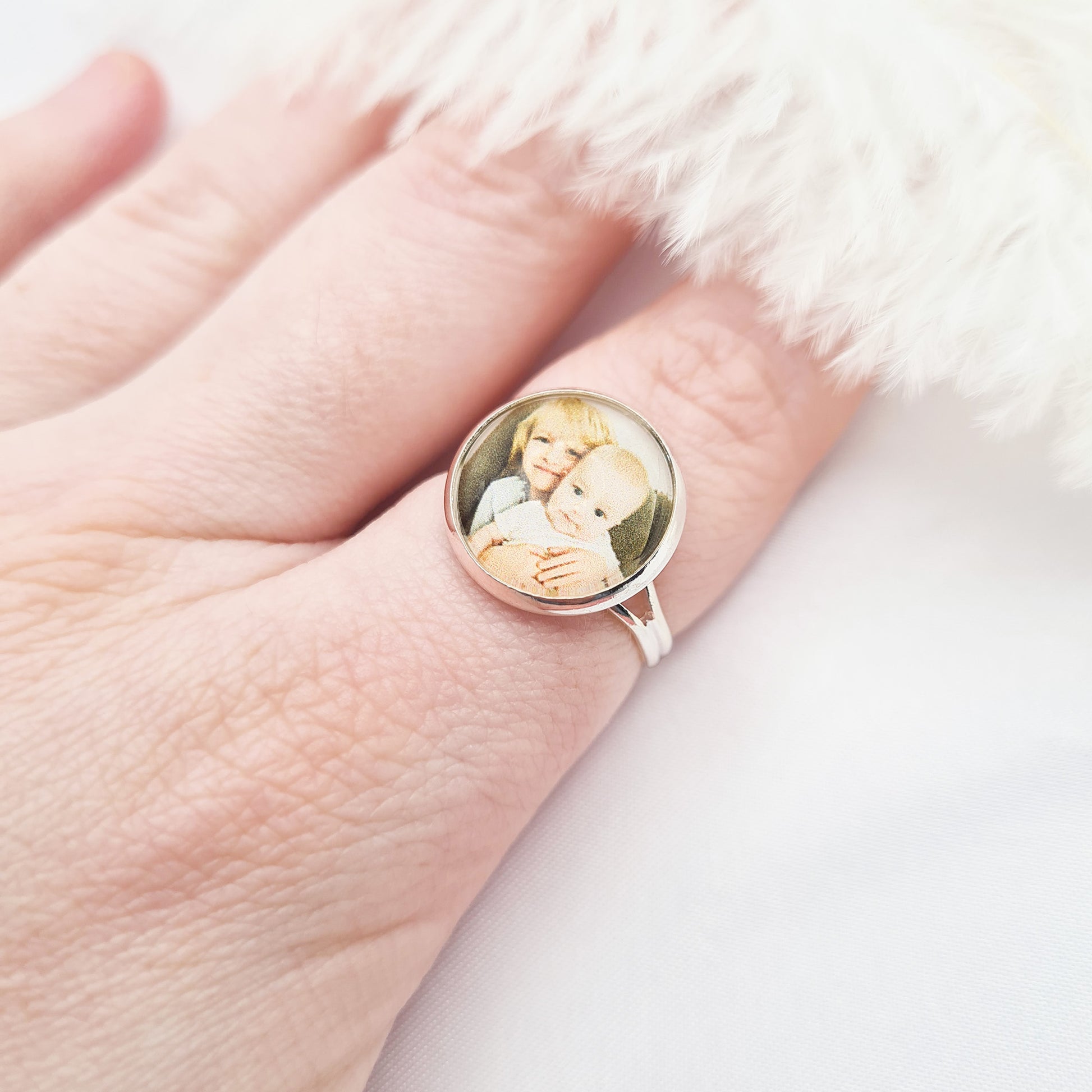 Silver ring personalised with a photo set in glass on a finger