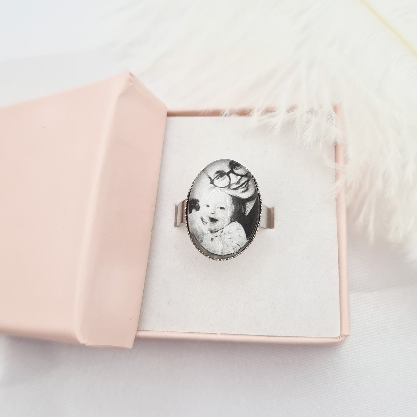 Silver oval ring personalised with a photo set in glass inside a pink decorative box