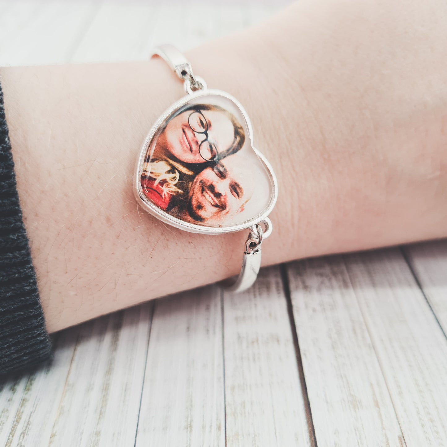 Silver heart shaped bracelet personalised with a photo set in glass worn on a wrist