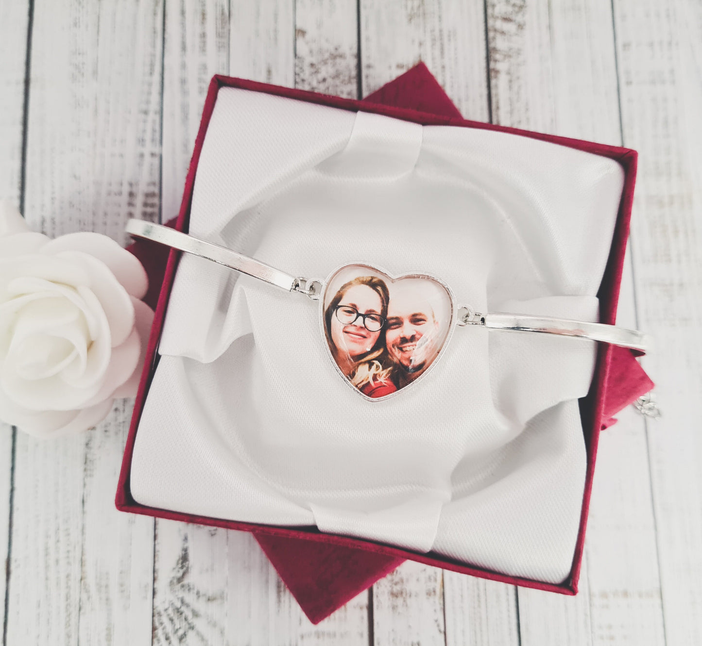 Silver heart shaped bracelet personalised with a photo set in glass inside a red gift box