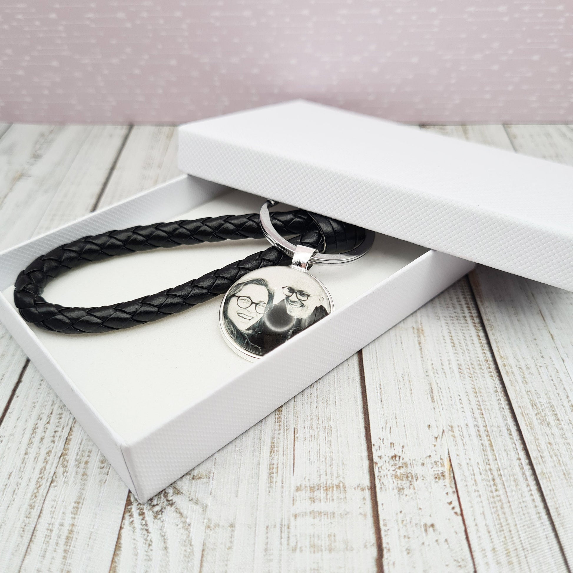 Black leather keyring with silver pendant in a white box