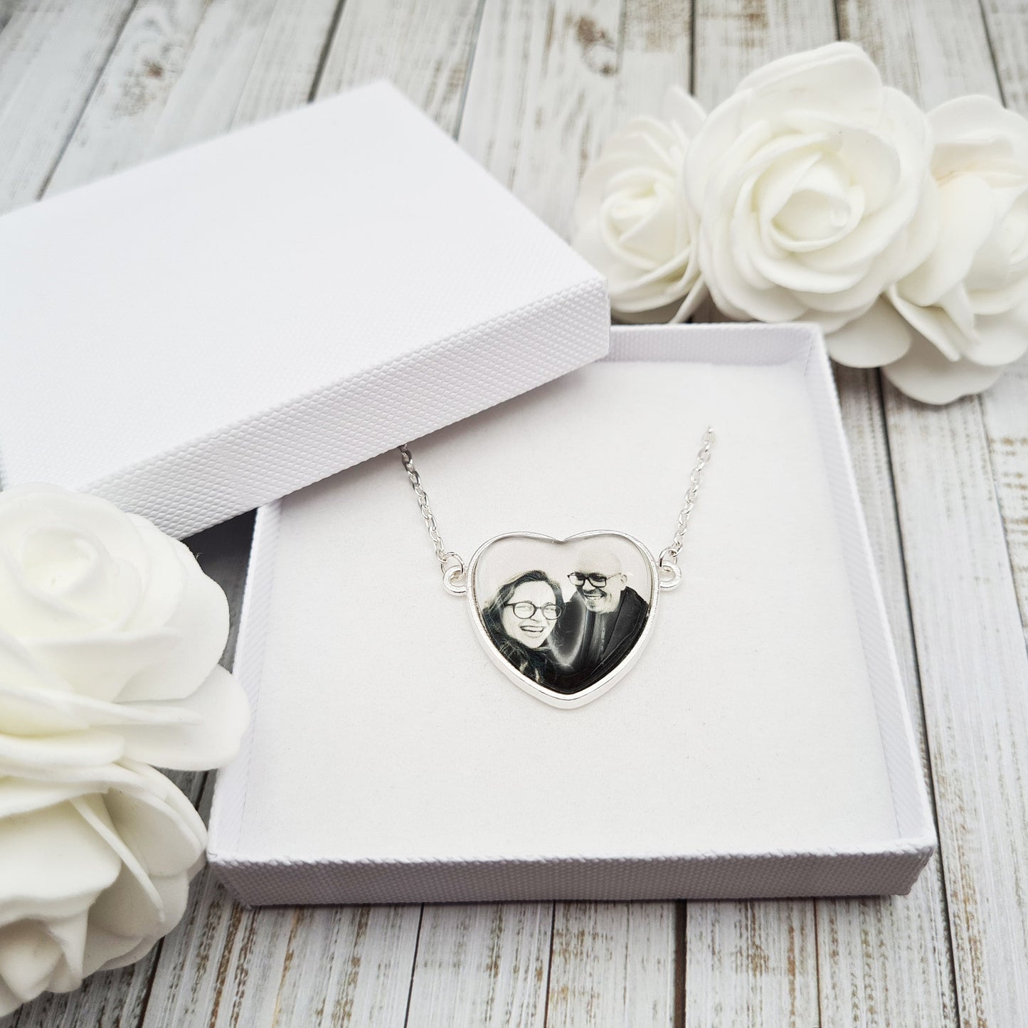 Heart shaped pendant personalised with a photo set in glass inside a white box