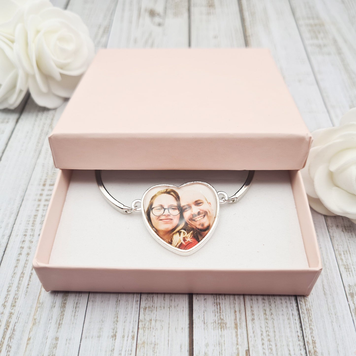 Silver heart shaped bracelet personalised with a photo set in glass inside a pink gift box