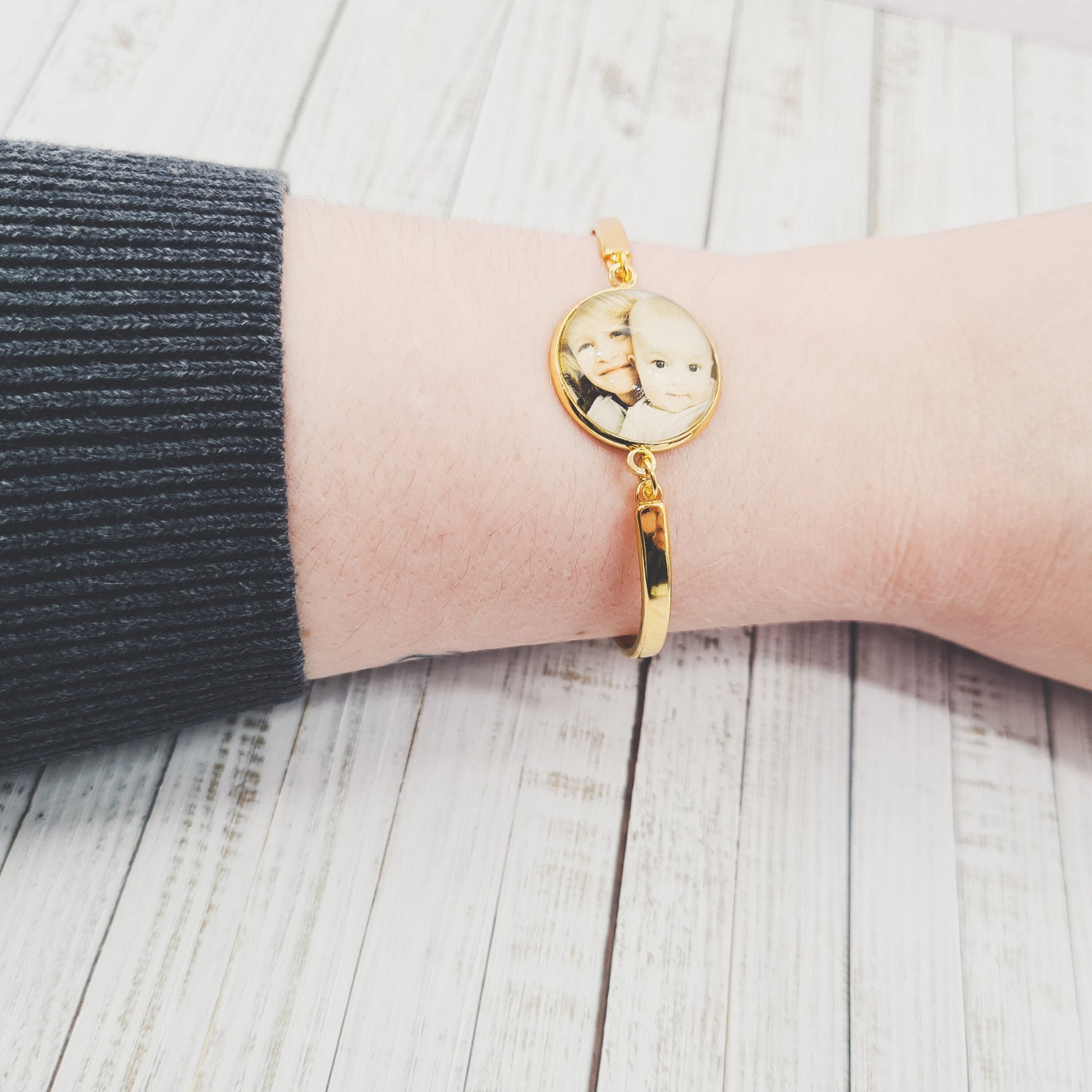 Gold bracelet personalised with a photo set in glass worn on a wrist