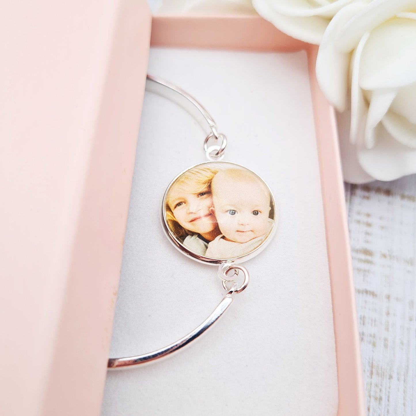 Silver bracelet with personalised photo set in glass inside a pink gift box