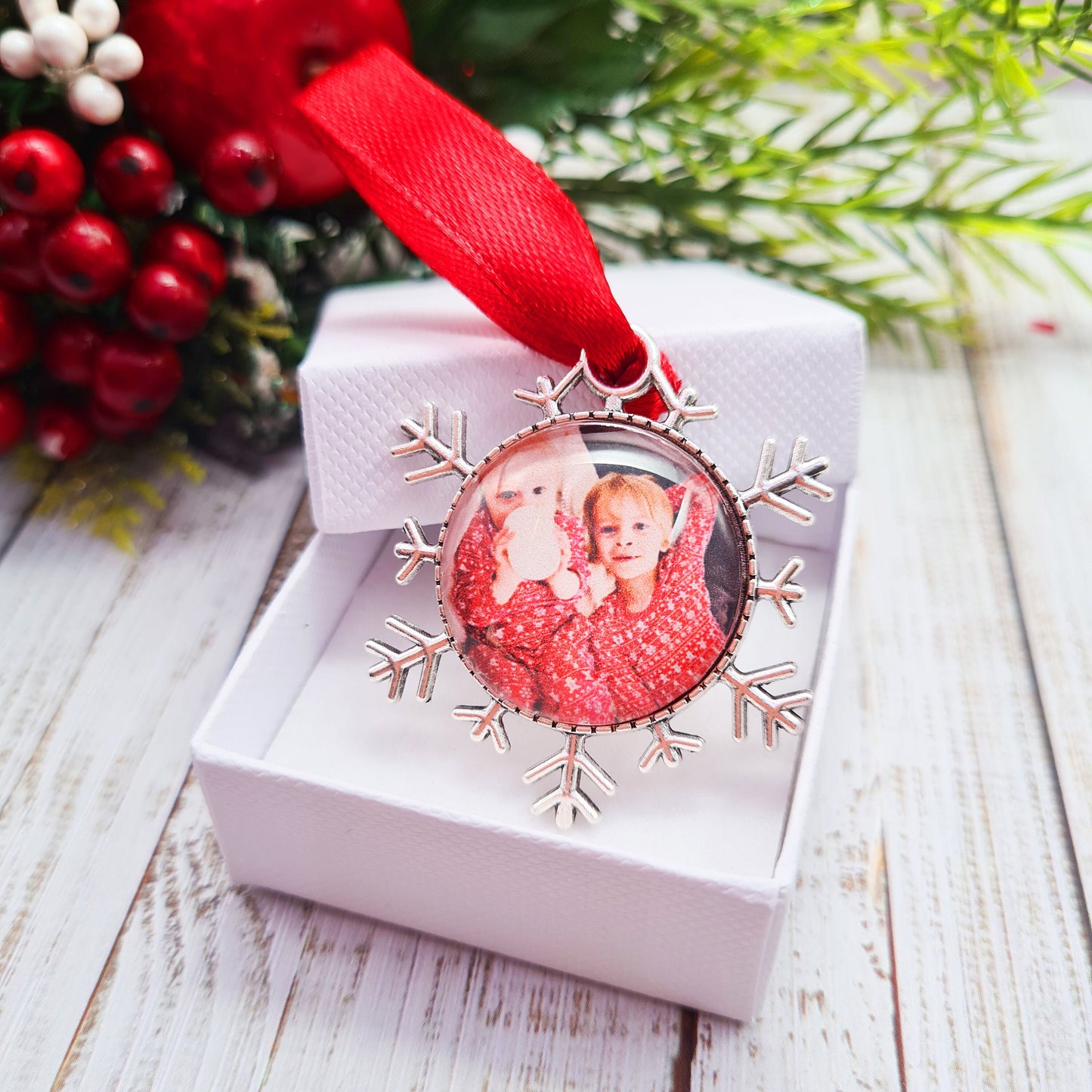 Christmas ornament personalised with photo with red ribbon inside a decorative box